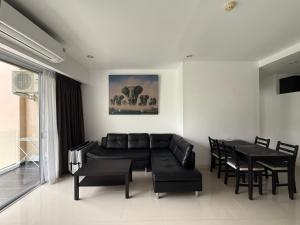 a living room with a couch and a table and chairs at Big Apartament with two bedrooms Karon in Phuket