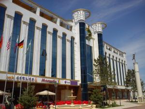 a large building with blue and white columns at Hamkor hotel in Andijan