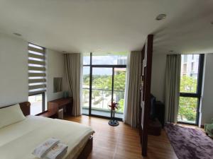 a hotel room with a bed and a large window at Coast Pearl Hotel in Phú Quốc