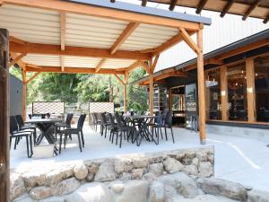 a patio with tables and chairs under a wooden pergola at 虎屋旅館 in Kotohira