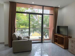 a living room with a couch and a large window at Coast Pearl Hotel in Phú Quốc