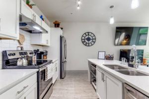 a kitchen with white cabinets and a stainless steel refrigerator at Riverwalk Pool View Condo Pets Free Parking in San Antonio +18 photos