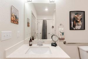 a white bathroom with a sink and a mirror at Riverwalk Pool View Condo Pets Free Parking in San Antonio