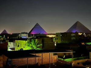 a view of the pyramids of egypt at night at Zein Pyramids View - Guest House in Cairo