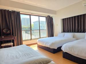 a hotel room with two beds and a large window at 禅 Zen 鹿児島 フロア貸切 中央駅徒歩14分 in Yamashitachō
