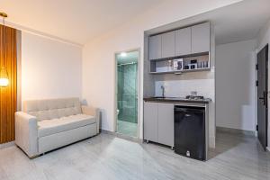 a living room with a couch and a sink and a kitchen at Hotel Radix Living in Medellín