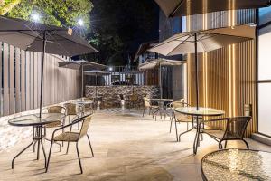 a patio with tables and chairs and umbrellas at Hotel Radix Living in Medellín