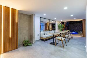 a restaurant with tables and chairs and a couch at Hotel Radix Living in Medellín +154 photos