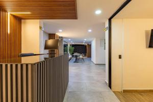 an office lobby with a counter and a hallway at Hotel Radix Living in Medellín
