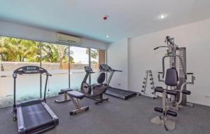 a gym with several treadmills and exercise bikes in it at Big Apartament with two bedrooms Karon in Phuket