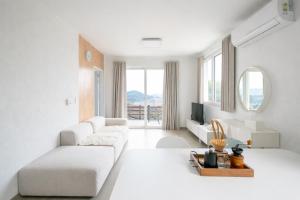 a white living room with a couch and a tv at 남해독일마을드레스덴 in Samhwa-dong