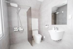 a bathroom with a shower and a toilet and a sink at 남해독일마을드레스덴 in Samhwa-dong +10 photos
