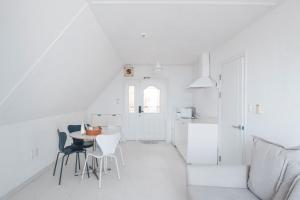 a white kitchen with a table and chairs at 남해독일마을드레스덴 in Samhwa-dong