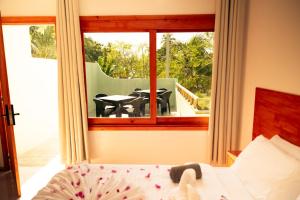 a bedroom with a bed and a balcony with a table and chairs at Ari Paradise in Hangnaameedhoo
