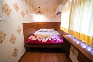 a small bedroom with a bed and a window at Hotel Tulsi in Nadiād +6 photos
