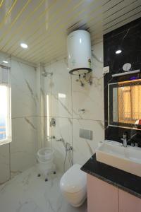 a bathroom with a toilet and a sink at Supreme Sapphire Kufri in Fagu +26 photos