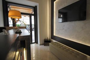 ein Wohnzimmer mit einem Sofa und einem TV an der Wand in der Unterkunft Hotel Charter in Rom