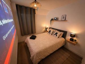 a bedroom with a bed with two pillows on it at Appartement Cosy Trelazé in Trélazé