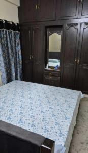 a bedroom with a bed with a dresser and a mirror at Villa Dome Retreat in Kanchipuram