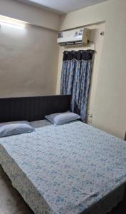 a bedroom with a bed with a blue comforter at Villa Dome Retreat in Kanchipuram