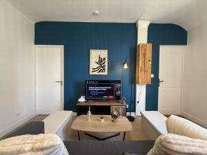 a living room with a couch and a tv at Appartement Cosy Trelazé in Trélazé