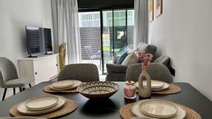 a living room with a table with plates and a vase at Atrio Homes Sansueña in Córdoba