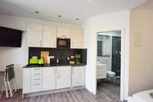 a kitchen with white cabinets and a toilet at Bootshaus Pritzerbe in Kützkow +51 photos