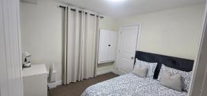 a bedroom with a bed with a blue and white blanket at Cozy Basement Suite in Lower Sackville