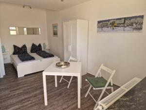 a living room with a white couch and a table and chair at Bootshaus Pritzerbe in Kützkow