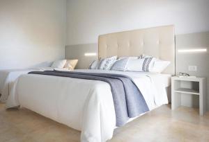 a large white bed with a blue blanket on it at Hotel Aron Rimini in Rimini +53 photos