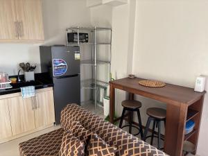 a kitchen with a refrigerator and a table with stools at Studio condo oceanside - pools, gym, mini market in Dao