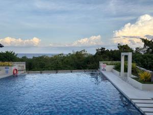 a swimming pool with a view of the ocean at Studio condo oceanside - pools, gym, mini market in Dao