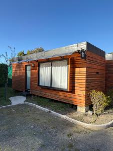 a wooden cabin with a window on the side of it at Alojamiento Borde Río habitación in Concepción