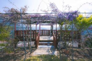 eine hölzerne Pergola mit lila Blumen darauf in der Unterkunft Stellar Twilight Ｘ in Huan-shan
