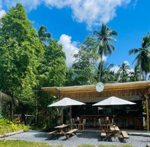 a restaurant with tables and umbrellas in front of it at Tiny Secret in Ban Tai