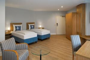 a hotel room with two beds and a table at Four Points Flex by Sheraton Kiel in Kiel