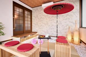 a room with red chairs and a table with a red umbrella at R STAY Nagoya Atsuta in Nagoya