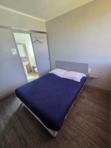 a bedroom with a bed with a blue comforter and a mirror at Le Bel Air - Decize in Decize