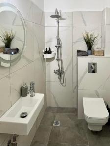 a white bathroom with a sink and a toilet at Nikoletta's Studio in Komotini