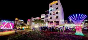 a group of people standing in front of a building with christmas lights at Hotel Luxstay in Pleiku