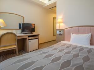 ein Hotelzimmer mit Bett und Fernseher in der Unterkunft Hotel Global View Iwaki in Iwaki + 111 Fotos