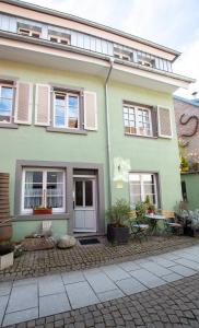 a green house with white windows and a patio at Schwarzwald Ferienhäuser in Haslach im Kinzigtal