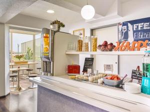 a fast food restaurant with a counter with food at ibis budget Santeny in Santeny +34 photos