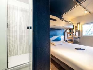 a small room with a bed and a window at Ibis Budget Sucy en Brie in Sucy-en-Brie
