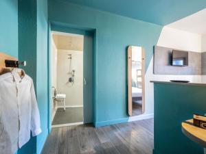a bathroom with blue walls and a mirror at Ibis Budget Sucy en Brie in Sucy-en-Brie +35 photos
