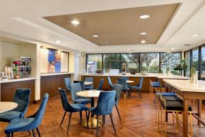 a restaurant with blue chairs and tables and windows at Comfort Inn Bellingham in Bellingham