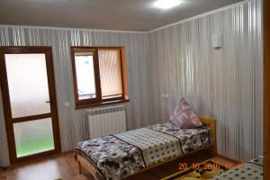 a small bedroom with a bed and a window at Cottage 5 in Karpaty