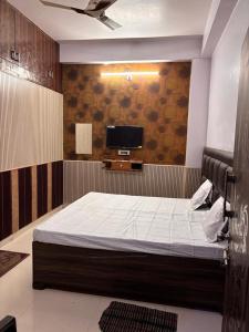 a bedroom with a bed and a flat screen tv at Absolute hostel in Meerut +2 photos
