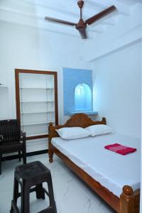 a bedroom with a bed and a ceiling fan at Le Lagrave Inn in Pondicherry