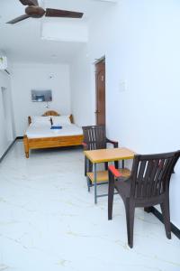 a bedroom with a bed and a table and chairs at Le Lagrave Inn in Pondicherry